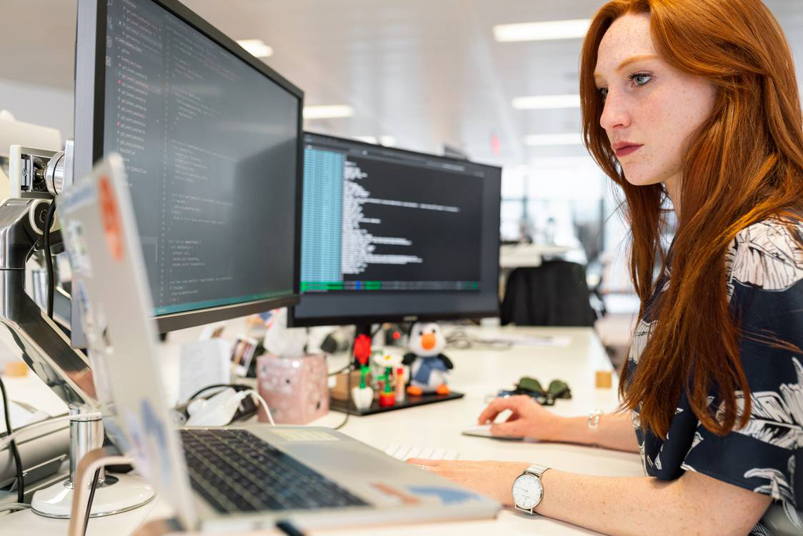 A woman using a computer in the office.